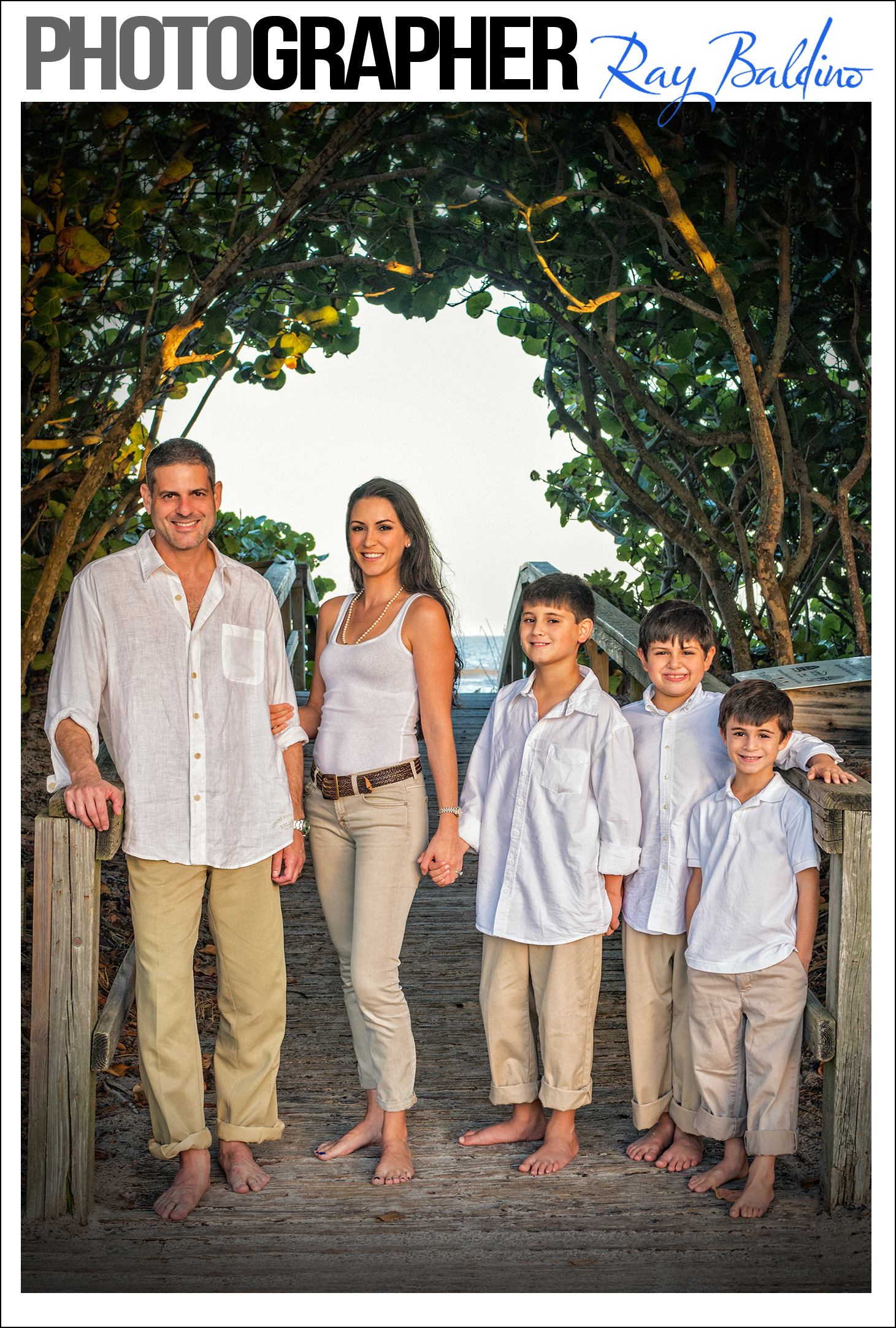 family-beach-photography-by-ray-baldino-in-cocoa-beach-florida-this-image-is-a-picture-of-a-family-with-their-children-standing-in-front-of-the-entrance-to-the-beach
